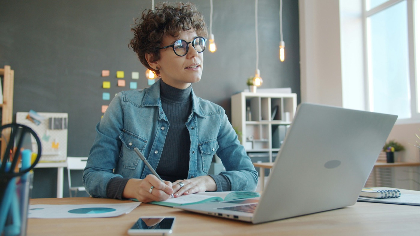 An expert taking notes at a laptop